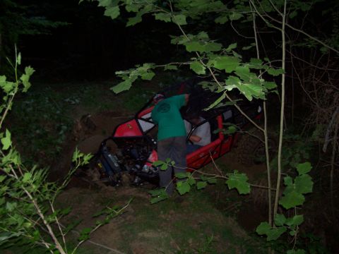1989 Ford Bronco II - An off-road vehicle is stuck in the dirt at night, with two occupants visible inside.