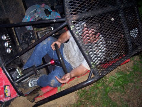 1989 Ford Bronco II - Driver sits inside a custom off-road buggy with a prominent roll cage structure.