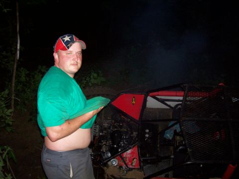 1989 Ford Bronco II - A man poses next to a custom-built off-road vehicle at night.