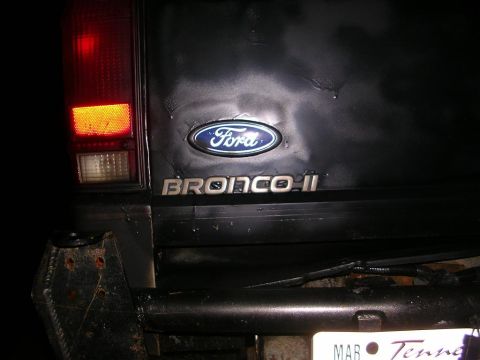 1989 Ford Bronco II - The rear of a black Ford Bronco II is shown, highlighting the Ford emblem and Bronco II badging.