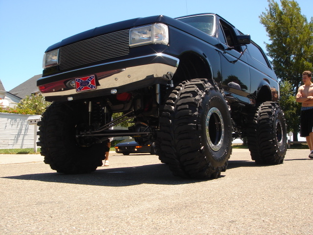 Black 1991 Ford Bronco with massive off-road tires and chrome grille