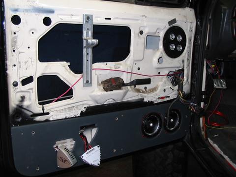 1991 Ford Bronco - Aftermarket speakers and wiring installed on the interior door panel of a vehicle.