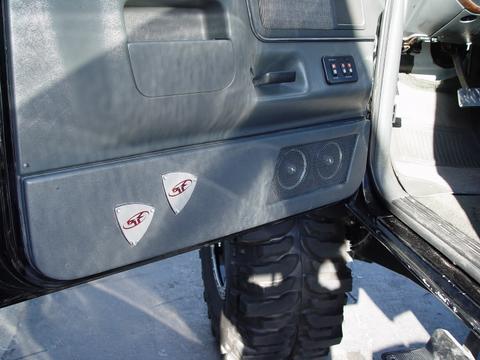 1991 Ford Bronco - Custom emblems and speakers are installed on the interior door panel of a vehicle.