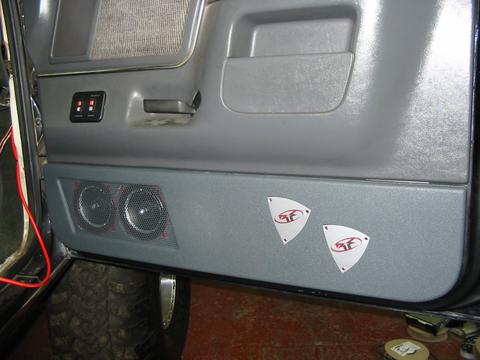 1991 Ford Bronco - Interior view of a vehicle door panel, showing aftermarket speakers and decorative decals.