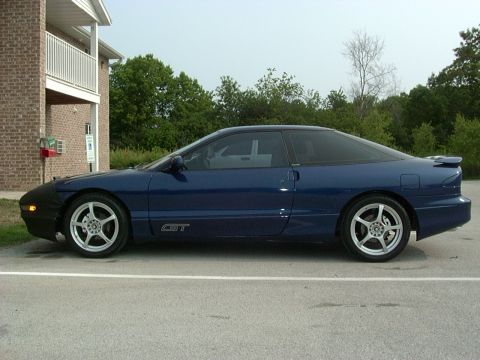 1995 Ford Probe - Side view of a blue 1995 Ford Probe GT with a car cover on the front bumper.