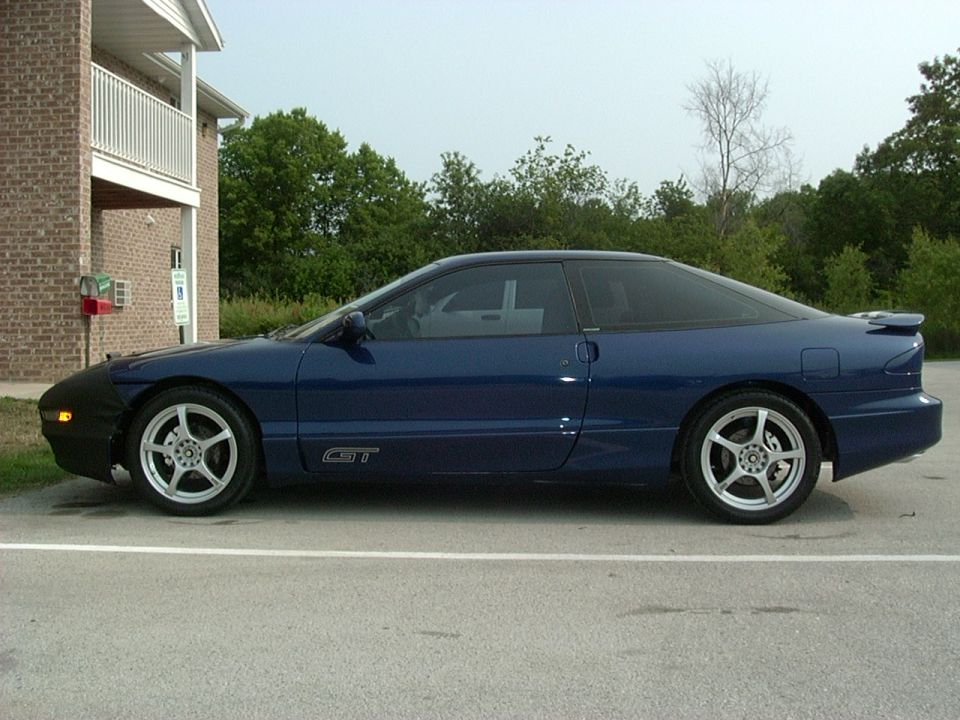 Blue 1995 Ford Probe GT parked outside brick building, front car cover installed