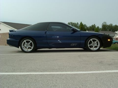 1995 Ford Probe - Side profile of a blue 1995 Ford Probe GT with aftermarket wheels and a black car bra.