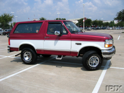 1995 Ford Bronco - This two-tone red and white Ford Bronco is captured from a three-quarter front view in a parking lot.