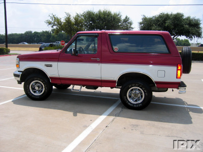 1995 Ford Bronco - This two-tone Ford Bronco is shown from the side, with a spare tire on the rear tailgate.