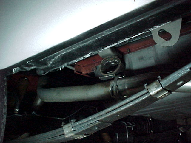 Vehicle underside showing exhaust pipe and leaf spring suspension