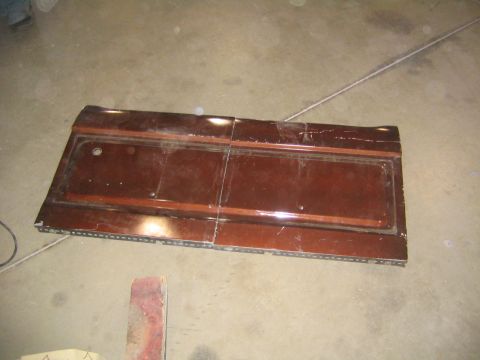 1982 Ford Bronco - A single car door panel, likely from an older vehicle, is shown disassembled on a workshop floor.