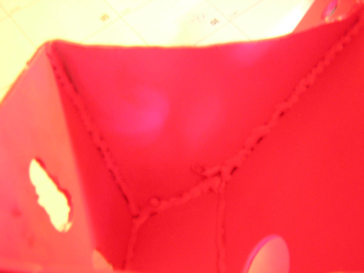 Blurry extreme close-up of a glossy red surface with small holes