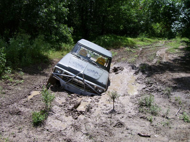off-road vehicle stuck in a mud pit on a trail