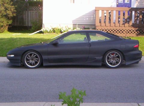 1993 Ford Probe - A black 1993 Ford Probe is seen from the side, custom wheels and a matte finish.