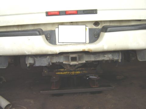 1992 Ford Bronco - The rear of a vehicle is shown, a trailer hitch and a blank license plate area.