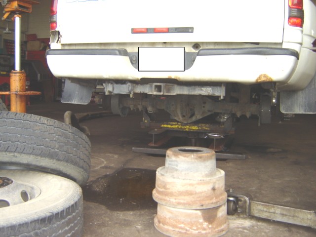 Rear bumper and undercarriage of a white truck with a tow hitch