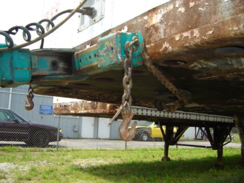1992 Ford Bronco - Close-up of a trailer hitch and chains, with a purple car and yellow truck visible in the background.