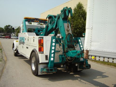 1992 Ford Bronco - A Cooper tow truck is shown from the rear, attached to a trailer.