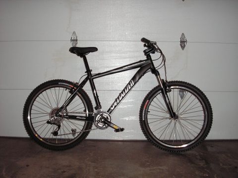 1997 Ford Probe - A black Specialized Hardrock mountain bike is parked in front of a garage door.