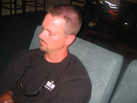1992 Ford Mustang - A man sits with his eyes closed, wearing a black t-shirt and sunglasses.