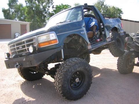 1994 Ford Bronco - This heavily modified Ford Bronco is parked on uneven terrain, its off-road capabilities.