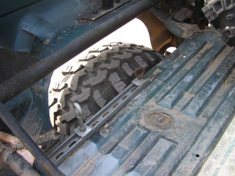 1994 Ford Bronco - Close-up view of the spare tire and the textured floor of the vehicle's cargo area.