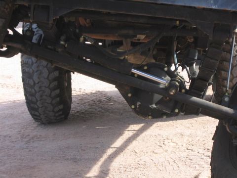 1994 Ford Bronco - Close-up view of the undercarriage of a vehicle, focusing on suspension and drivetrain components.