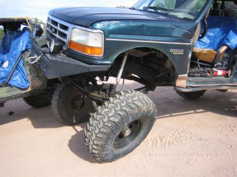 1994 Ford Bronco - A green 1994 Ford Bronco is shown with a lifted suspension and oversized off-road tires.