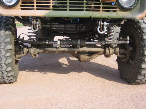 1994 Ford Bronco - Close-up of the front axle and suspension system on a heavily modified off-road vehicle.