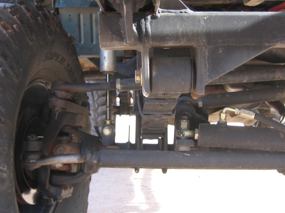 Close-up of vehicle suspension components, including leaf springs and steering linkage