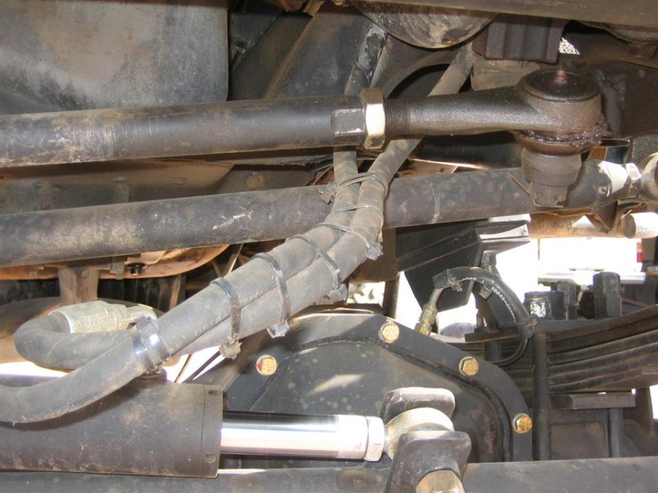 Close-up of vehicle steering linkage and differential with Supermotors.net watermark