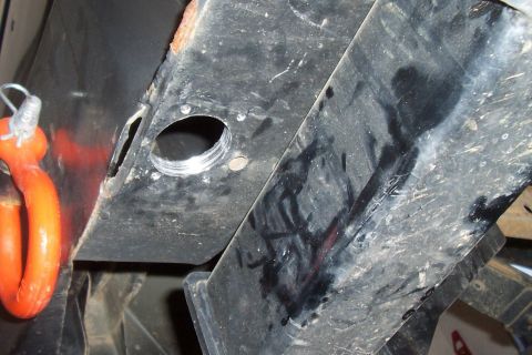 1994 Ford F-150 - Close-up of an orange tow hook and part of a vehicle's frame, showing a threaded hole.