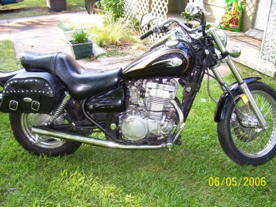 1972 Ford Ranchero - Motorcycle with studded saddlebags parked on a grassy lawn.