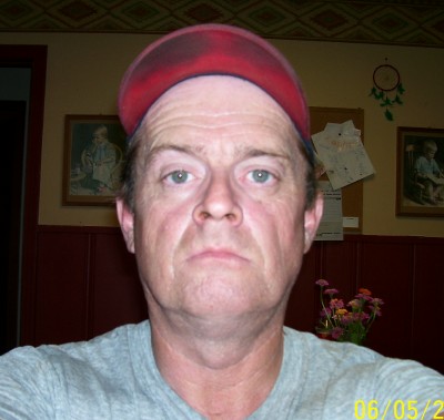 1972 Ford Ranchero - Man in a red cap poses for a photo indoors, with framed pictures on the wall behind him.