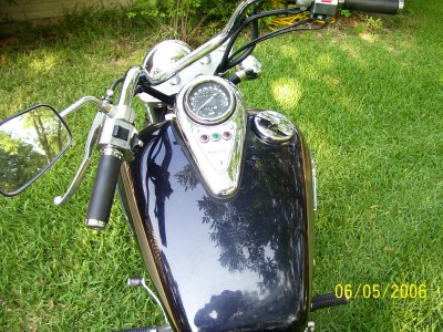 1972 Ford Ranchero - A motorcycle's dashboard and fuel tank are visible, set against a backdrop of green grass.