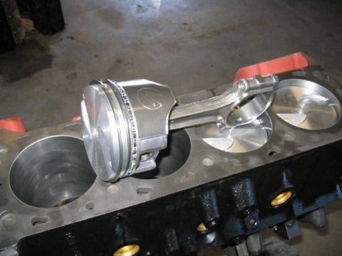 1979 Ford F-150 - Close-up of a piston and connecting rod assembly being fitted into an engine block, showing internal engine components.