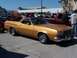 1973 Ford Ranchero - A gold 1972 Ford Ranchero is parked in a lot with people in the background.