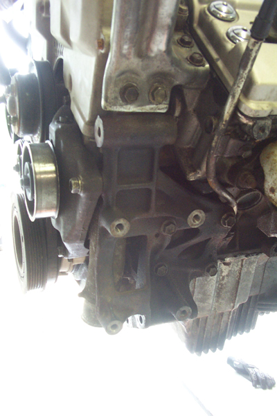 1995 Ford Taurus - Close-up of engine components, including pulleys and mounting brackets.