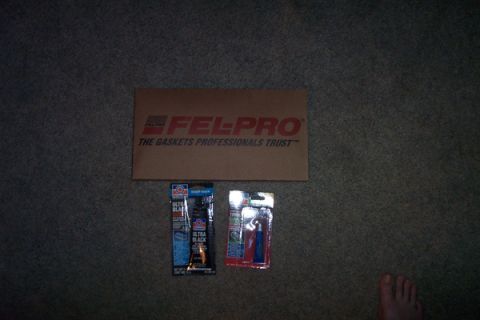 1995 Ford Taurus - A box of Fel-Pro gaskets and two tubes of automotive sealant are laid out on a carpeted surface.