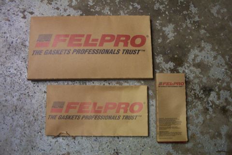 1995 Ford Taurus - Cardboard packaging for Fel-Pro gaskets is laid out on a textured concrete surface.