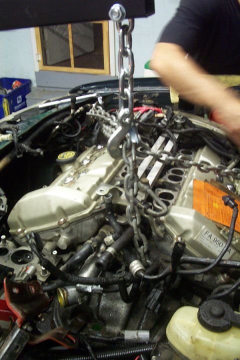 1995 Ford Taurus - Engine removal in progress with a chain hoist. Part number FA 950 is visible on the engine.
