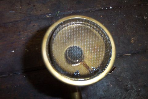 1995 Ford Taurus - Close-up of an oil pump screen, likely from an engine, resting on a wooden surface.