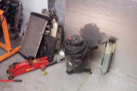 1995 Ford Taurus - Various engine components and tools are laid out on the garage floor.