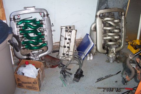1995 Ford Taurus - Engine components, including intake manifolds and spark plug wires, are laid out on a garage floor.