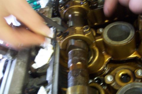 1995 Ford Taurus - Mechanic's hands work on an engine's internal components, likely during a refresh or swap.