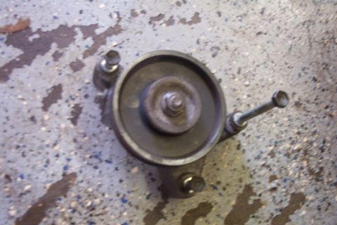 1995 Ford Taurus - A pulley assembly with bolts is shown on a concrete floor.