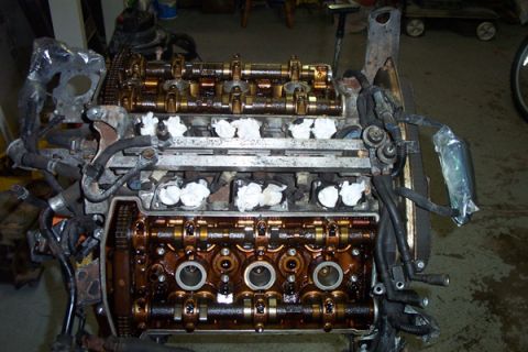 1995 Ford Taurus - Engine components are visible, including camshafts, valves, and spark plug wells, with some parts covered in oil.