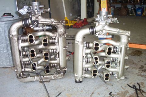 1995 Ford Taurus - Two intake manifolds are shown side-by-side on a garage floor.