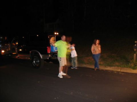 1995 Ford Bronco - A black 1995 Ford Bronco is parked at night with its rear hatch open and people gathered around.