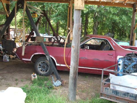 1972 Ford Ranchero - 1972 Ford Ranchero undergoing repairs or restoration under a shelter, engine appears to be out.